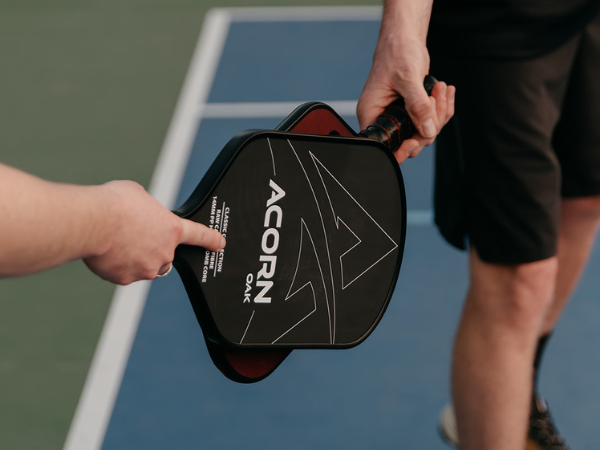 The Acorn Oak pickleball paddle cheersing with the Acorn Infinity